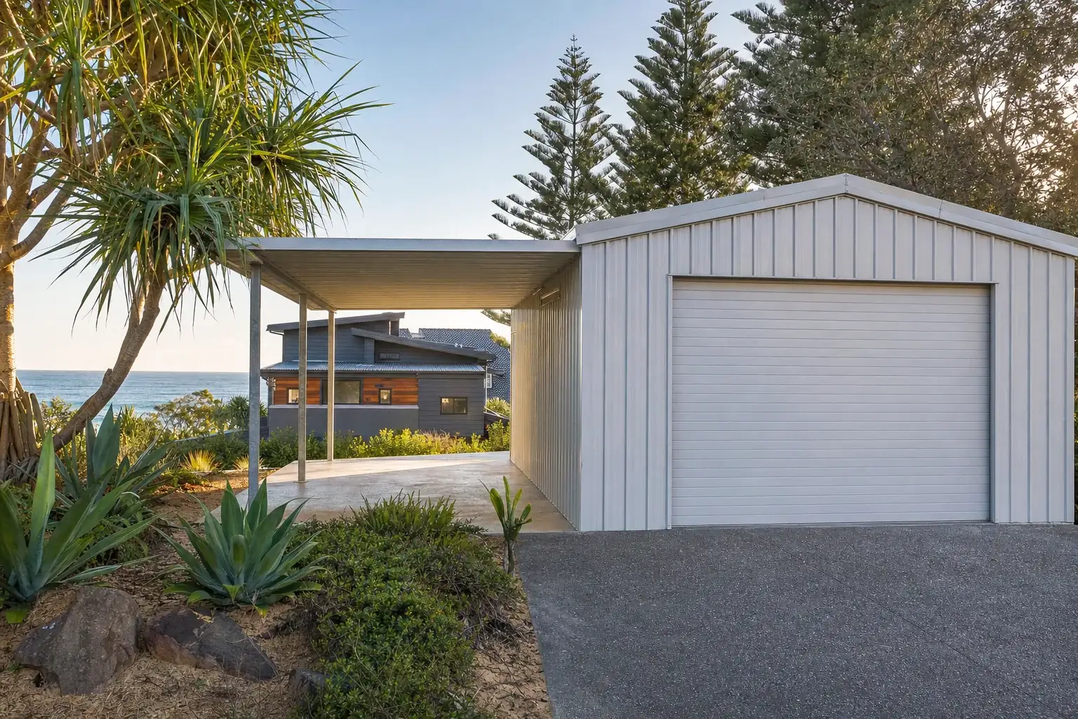 Light grey garage shed with an attached carport beside a coastal home in Tweed Heads
